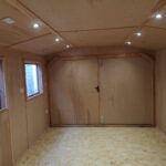 inside of a new timber workshop with 6 spotlights in the roof and a window on the left side